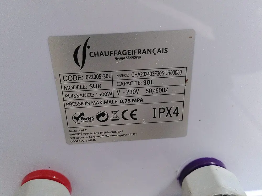 Plaque signalétique du chauffe-eau installé : Chauffage Français, modèle SUR, capacité 30 litres, 1500 W, indice de protection IPX4, avec ses deux raccords d'eau.